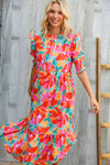 Woman wearing a colorful floral dress against a wooden background