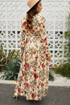 Back view of model wearing size small boho floral maxi dress with frill accents and long flounce sleeves.