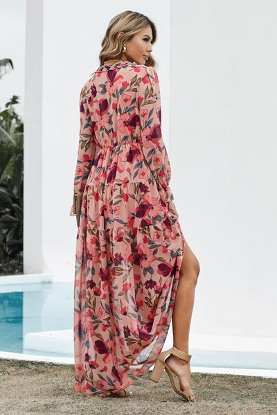 Back view of model wearing size small pink ruched midi dress with long sleeves and smooth, lined finish.