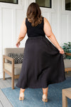 Back view of plus size satin black maxi skirt with elastic waistband and long hem
