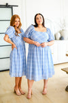 two models, one plus size one straight size showing modest blue plaid midi dress with puff sleeves and smocked bodice shown from the front