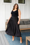 Plus size model wearing black modest satin A-line maxi skirt in 1XL.