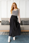 Model wearing modest black satin A-line maxi skirt, size small