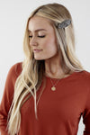Close up of Rich-toned modest knit dress with long puff sleeves, straight silhouette, and knee-length hem, made from cozy polyester-rayon-spandex blend