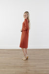 Side shot of rich-toned modest knit dress with long puff sleeves, straight silhouette, and knee-length hem, made from cozy polyester-rayon-spandex blend