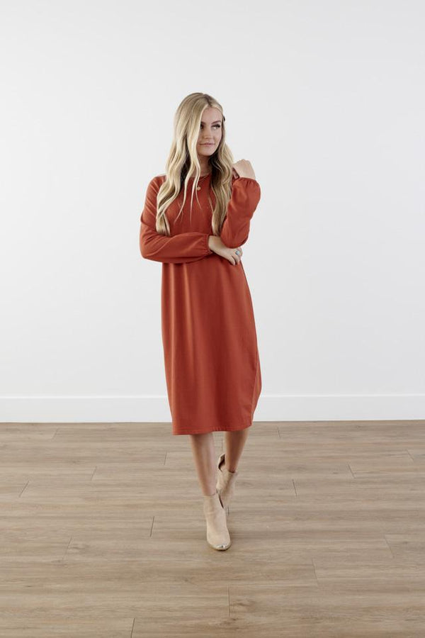 Rich-toned modest knit dress with long puff sleeves, straight silhouette, and knee-length hem, made from cozy polyester-rayon-spandex blend
