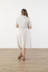 Back view of Plus size cotton midi dress with chest pocket, decorative side buttons, elastic waist with sash, and A-line skirt in breathable white fabric