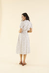 Back of cotton midi dress with chest pocket, decorative side buttons, elastic waist with sash, and A-line skirt in breathable white fabric