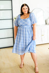 Modest blue plus size plaid midi dress with puff sleeves and smocked bodice shown from the front